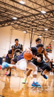 Basketball player driving to the basket past a defender
